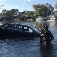 <p>Fairfield police help pull a car from Pine Creek on Friday.</p>