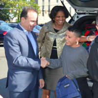 <p>Bridgeport Mayor Joe Ganim, left, and Schools Supt. Aresta Johnson, center, present 7th-grader Juan Casiano of Puerto Rico with a new backpack and school supplies as he gets ready to attend school in Bridgeport.</p>