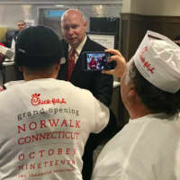 <p>Franchise owner Archer Bullock welcomes customers early Thursday at the new Chick-Fil-A in Norwalk.</p>