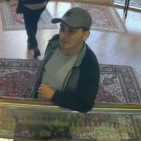 <p>The male suspect put the stolen items in a brown paper shopping bag he was carrying in the distraction-type theft at Campus Jewelers in Wilton. He is shown in a surveillance camera photo.</p>