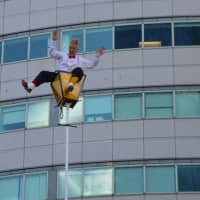 <p>Comedic daredevil Bello Nock shimmied up a stories-tall street lamp prop swaying in the breeze.</p>