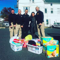 <p>Members of the Dumont Police Department and Daily Voice managing editor Cecilia Levine prepare to bring some supplies to the Roman family Tuesday.</p>