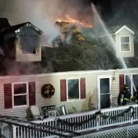 <p>Danbury firefighters tackle a burning home on Fleetwood Drive on Sunday evening.</p>