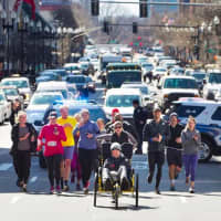 <p>Kaitlyn Kiely pushes Matt Wetherbee through the 26.2 mile Boston Marathon course.</p>