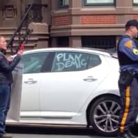 <p>A police officer issues summonses during an anti-lockdown protest in Trenton Friday.</p>