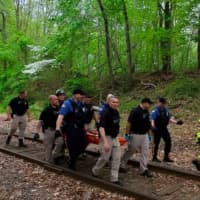 <p>Police and firefighters carry a rescued woman out of Thompson Park.</p>