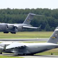 <p>A C-17A Globemaster III from the 305th Air Mobility Wing lands as another C-17A prepares to take off at Joint Air Base McGuire-Dix-Lakehurst in Burlington County,</p>