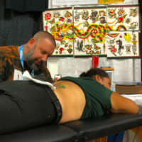 <p>Robert Kinzel, owner of R&amp;B Tattooing and Dominion Piercing, at work.</p>