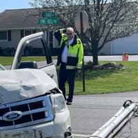 <p>An officer scratching his head while looking at the crash scene.</p>
