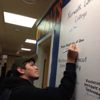 <p>Future 5 member and AITE senior Sebastian Neufuss signs his name on the college signing wall. Sebastian will attend Miami University of Ohio this fall where he will double major in psychology and business.</p>