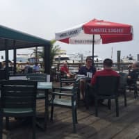 <p>A shaded awning area extends from the inside restaurant to the deck at Sunset Grill in Norwalk.</p>