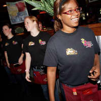 <p>Wait staff at a Texas Roadhouse entertain the customers with line dancing.</p>