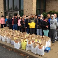 <p>The Forum School students display collected food donations.</p>