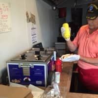 <p>Eugene Parrotta, puts a little mustard on a dog at Three Dog Bite, his new restaurant in Croton-on-Hudson.</p>