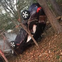 <p>A car flipped over and its engine caught fire after a crash in Trumbull on Monday</p>