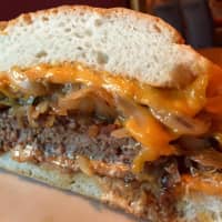<p>The Johnny&#x27;s Bronx Burger is served up at Valhalla Crossing. It comes topped with sautéed onions and mushrooms, cheddar cheese, and homemade chipotle sauce and is served on a rustic roll</p>