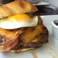<p>The Hangover Burger at WBC is topped with a fried egg, bacon, and Monterey Jack cheese.</p>