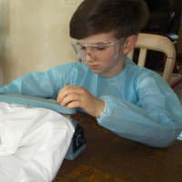 <p>Mark Leschinsky ,9, of Mahwah, works on his prototype for the self-disinfecting suit last year.</p>