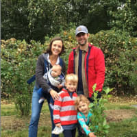<p>A family with blueberry bush it adopted at an orchard in Trout Brook Valley in Weston.</p>