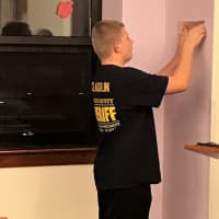 <p>Kevin hangs the plaque.</p>