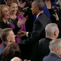 <p>Gabrielle Giffords reaches out to President Barack Obama before the State of the Union Address begins Tuesday night. Giffords, a former Congresswoman and gun violence victim, is sitting with U.S. Rep. Elizabeth Esty (D-Conn., 5th District).</p>
