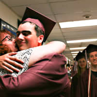 <p>Pat Carraturo, a teacher at Rockwell, greets her son Thomas as he paraded through the halls with the rest of the senior class.</p>