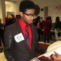 <p>A visitor stops at an information table during College Resource Night Feb. 8 in New Rochelle.</p>
