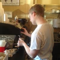 <p>A barista at The Black Cow in Pleasantville makes a latte.</p>