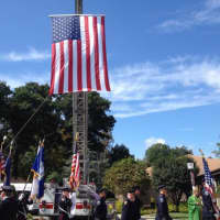 <p>A large American flag hung from a Norwalk Ladder Company fire truck during the Blue Mass at St. Matthew Parish in Norwalk</p>
