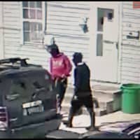 <p>CCTV stills of the suspects wearing a red and a black hoodie.</p>