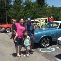 <p>An Atria resident and his family standing with the classic cars on display at the show.</p>