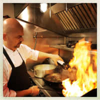 <p>The Village Tavern chef and owner Germano Minin prepares a dish in the newly opened restaurant on Main Street in Ridgefield.</p>