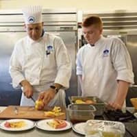 <p>Chef Jeff Trombetta instructs a Norwalk Community College culinary arts student in proper food preparation.</p>