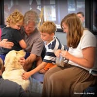 <p>Lindsey Clark, right, and her sons Miles, left, and Jeremy meet Valerii, a new service dog that will help the boys handle seizures associated with Dravet Syndrome.</p>