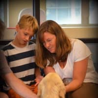 <p>Jeremy Clark, left and his mother, Lindsey, get to know Valerii, their new service dog.</p>