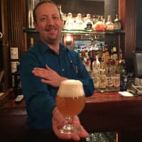 <p>Robert Beckert, co-owner of Craft House in Suffern, holds a glass filled with Kuka Ales for ALS Double IPA.</p>