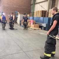 <p>Firefighters practice techniques for rescuing fallen crew members Saturday.</p>