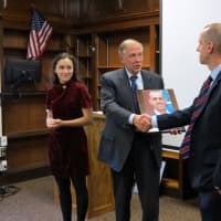 <p>Student Madeleine Camillieri, left, and Principal Alan Capasso present Benjamin Holzer with a plaque during the induction ceremony.</p>