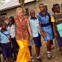<p>Nigerian schoolchildren take Teaneck&#x27;s Dena Grushkin for a walk through their village after dressing her up in traditional garb.</p>