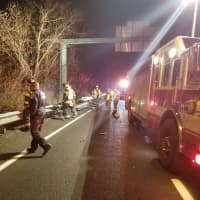 <p>Firefighters on the scene of a crash where a car went off the highway in Danbury on Monday</p>