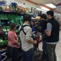 <p>Hannah Steinberg checks out items at DeCicco&#x27;s as a television crew tracks her.</p>