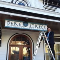 <p>Owner David Cooper hangs up the sign for his new eatery, Dere Street Restaurant, Bar &amp; Bakery.</p>
