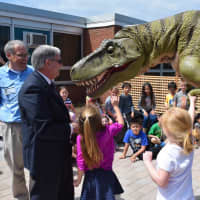 <p>Guy Gsell, Bergen County Executive James Tedesco and Parkway students get an up-close look at a dinosaur.</p>