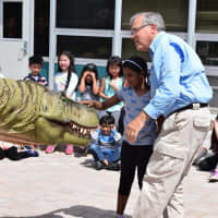 <p>Guy Gsell helped kids at Parkway School get up-close to a dinosaur on Wednesday.</p>