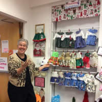 <p>Monica Weber shows off the Christmas, Hanukkah and Kwanzaa outfits available at the Doll Clothes Factory in Brookfield.</p>