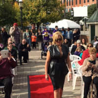 <p>An Ossining resident makes her way down the red-carpet runway during the Fall Food and Fashion Show at Market Square on Saturday.</p>
