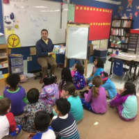 <p>State Representative Michael Ferguson reads looks up as he reads at King Street Primary School in Danbury.</p>
