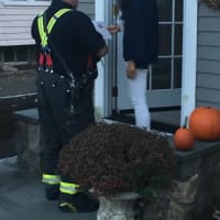 <p>Fairfield Fire Department personnel distribute literature to neighboring houses after Monday night’s fire on South Benson Road.</p>