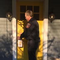 <p>Fairfield Fire Department personnel distribute literature to neighboring houses after Monday night’s fire on South Benson Road.</p>