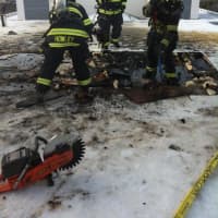 <p>Greenwich firefighters battle a small blaze on the roof of 100 W. Putnam Ave. on Sunday morning.</p>